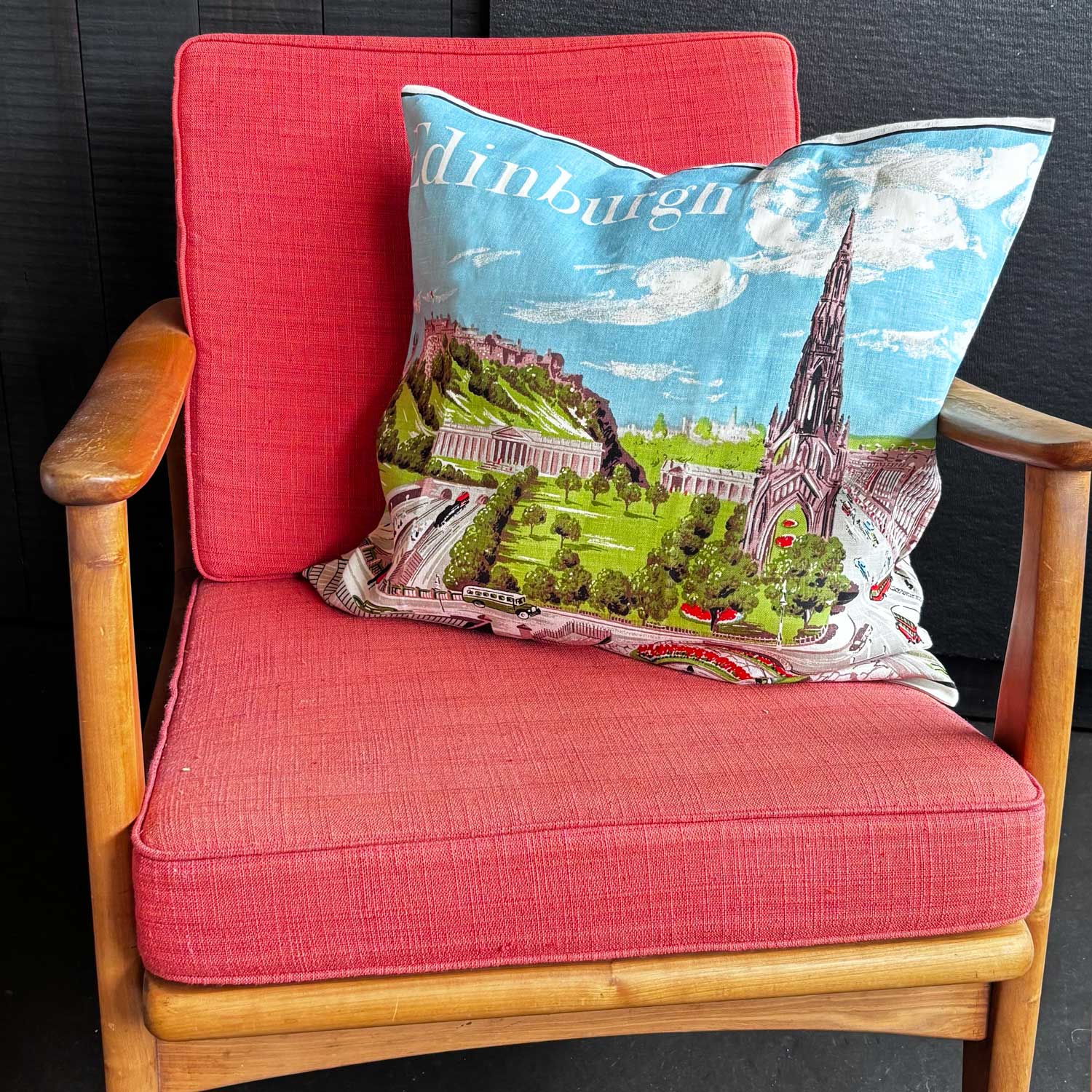 Decorative vintage teatowel pillow with a scenic illustration of Edinburgh featuring notable landmarks on mcm chair 