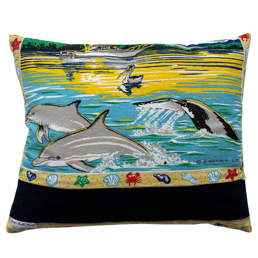 Decorative pillow with Merimbula, New South Wales design featuring a parrot and beach scenes on white background
