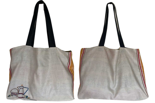 Tote bag made from antique linen teatowel with a hand-embroidered design of a jug and teacups, featuring denim handles.