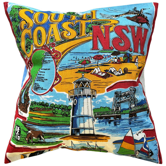 Decorative pillow with a colorful design of South Coast NSW featuring a lighthouse, beach, and bridge.