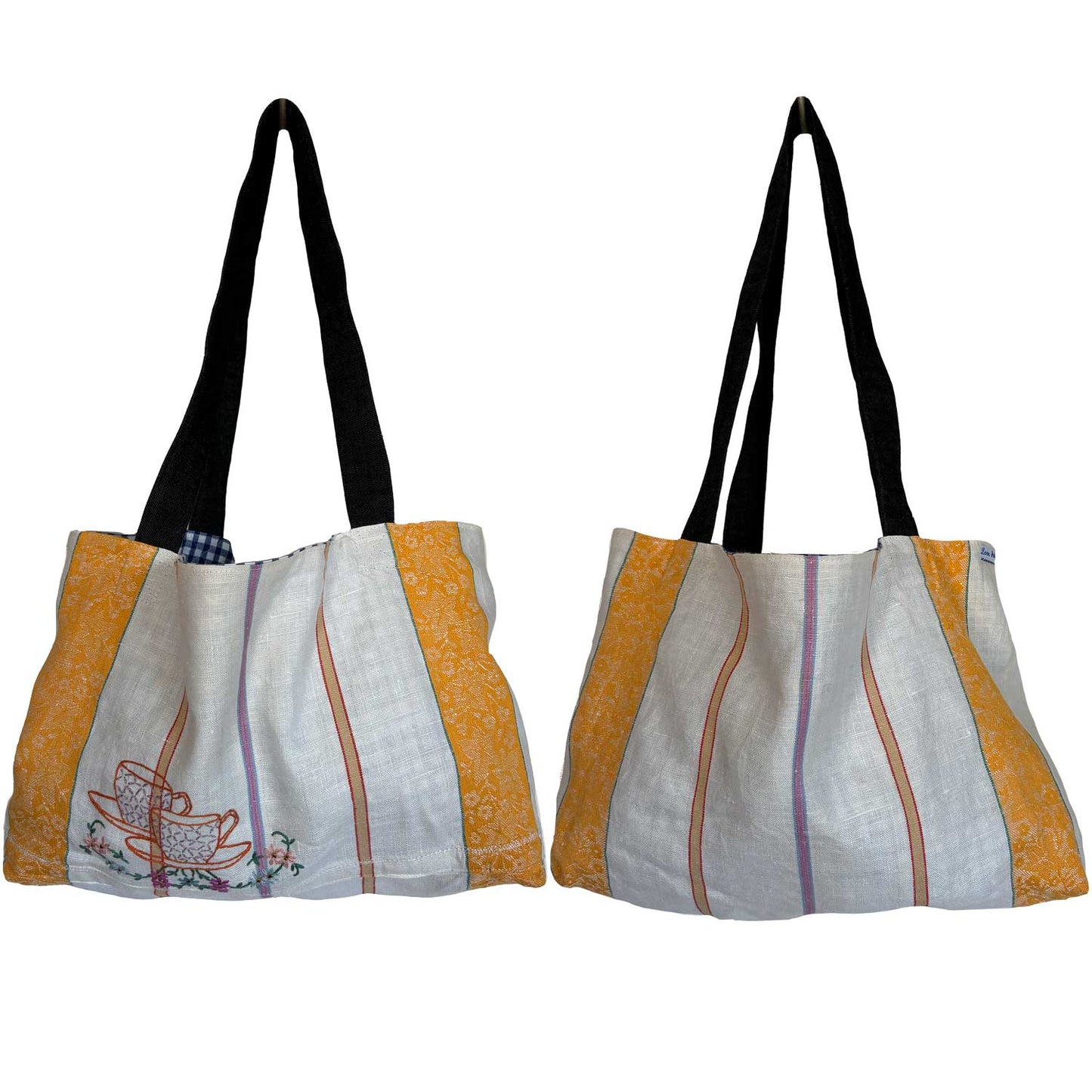 Tote bag made from antique linen teatowel with a hand-embroidered design of teacups, featuring denim handles.