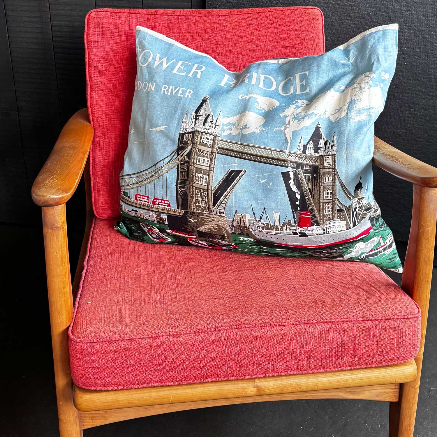 Decorative vintage linen teatowel pillow with Tower Bridge and Thames River design on mcm chair