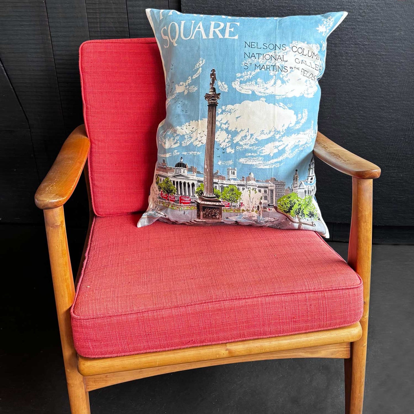 Decorative tea towel pillow with a design of Trafalgar Square, Nelson's Column and surrounding buildings with blue sky, on mcm chair